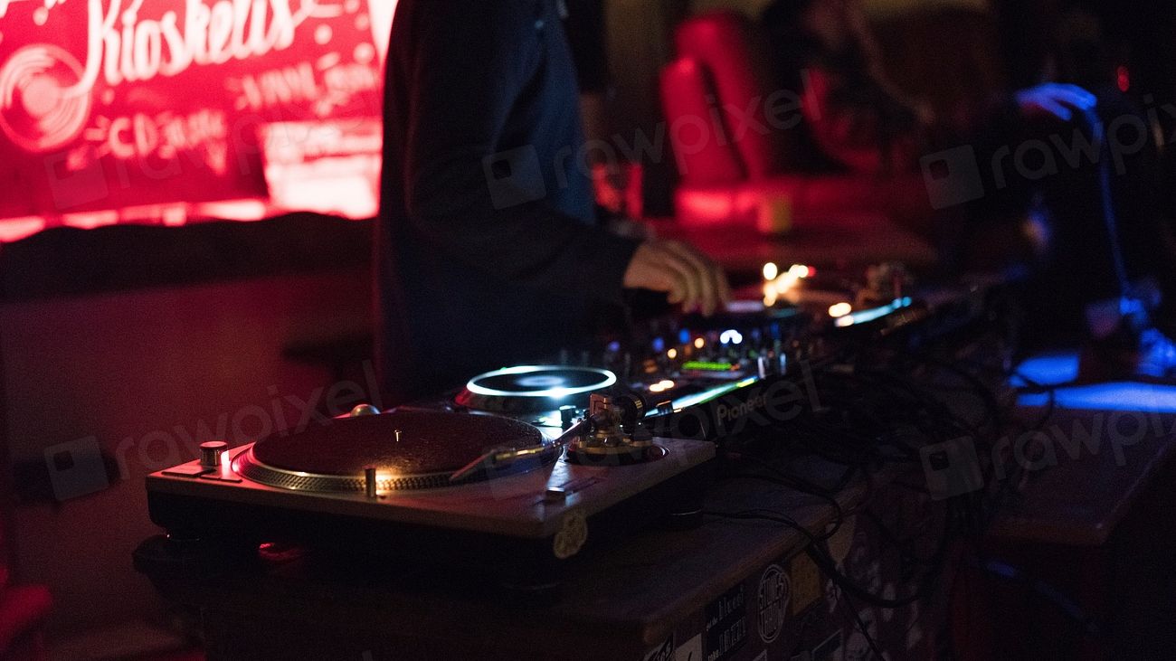 A DJ working the decks in a red-lit club